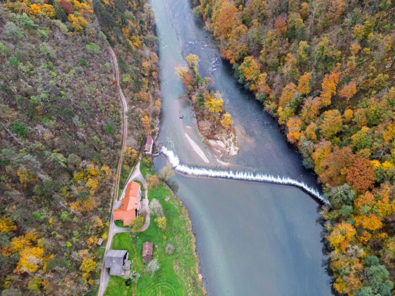 Slika prikazuje posnetek z dronom. Na liki je Breška malenca, jez na reki Kolpi in kolpski otok.