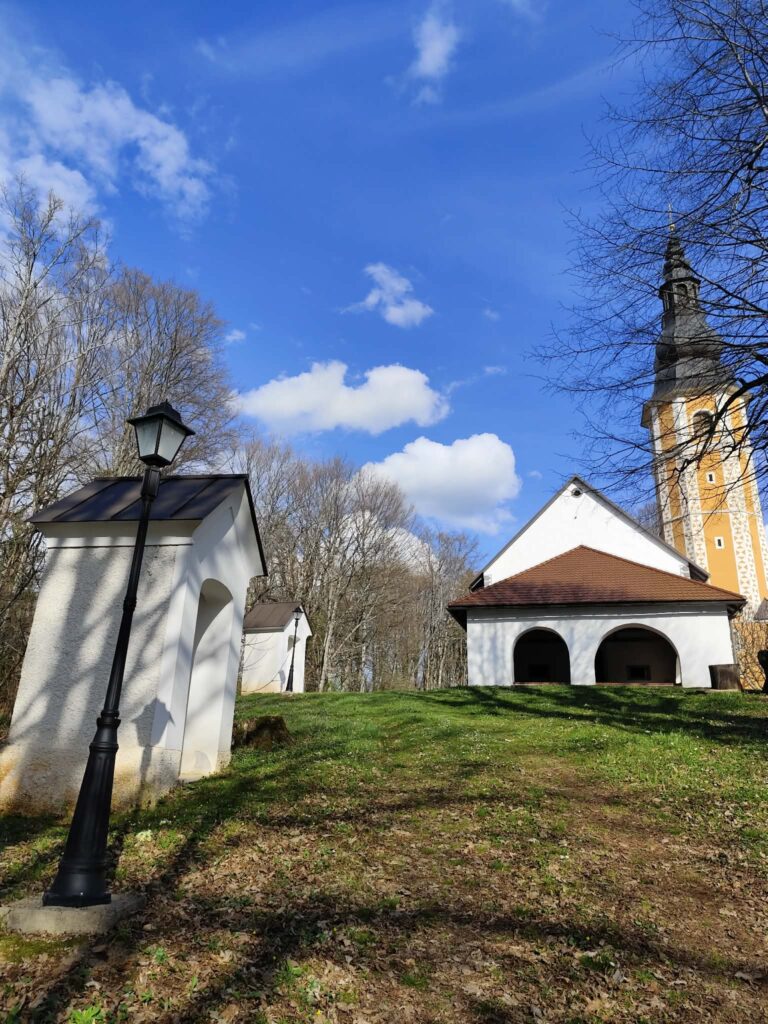 Slika prikazuje cerkev na Žežlju in dve kapelici, ki stojita ob poti na Žeželj.